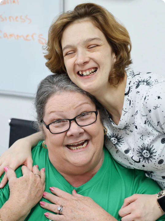 a happy female patient and female staff memeber embracing one another
