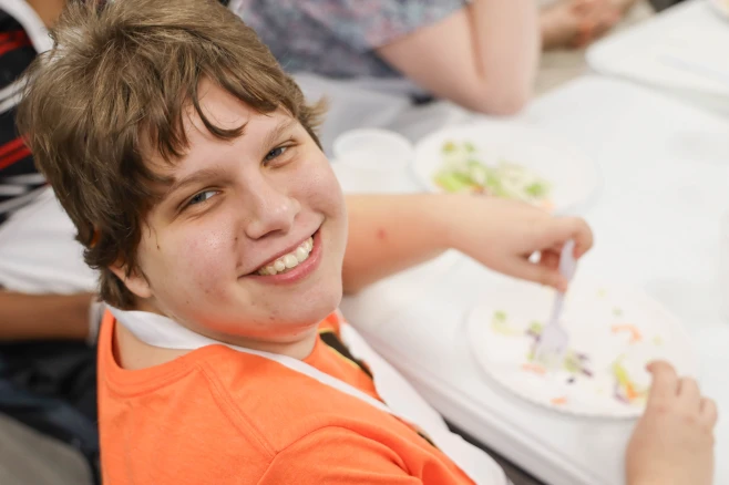 Young woman busy eating food and smiling