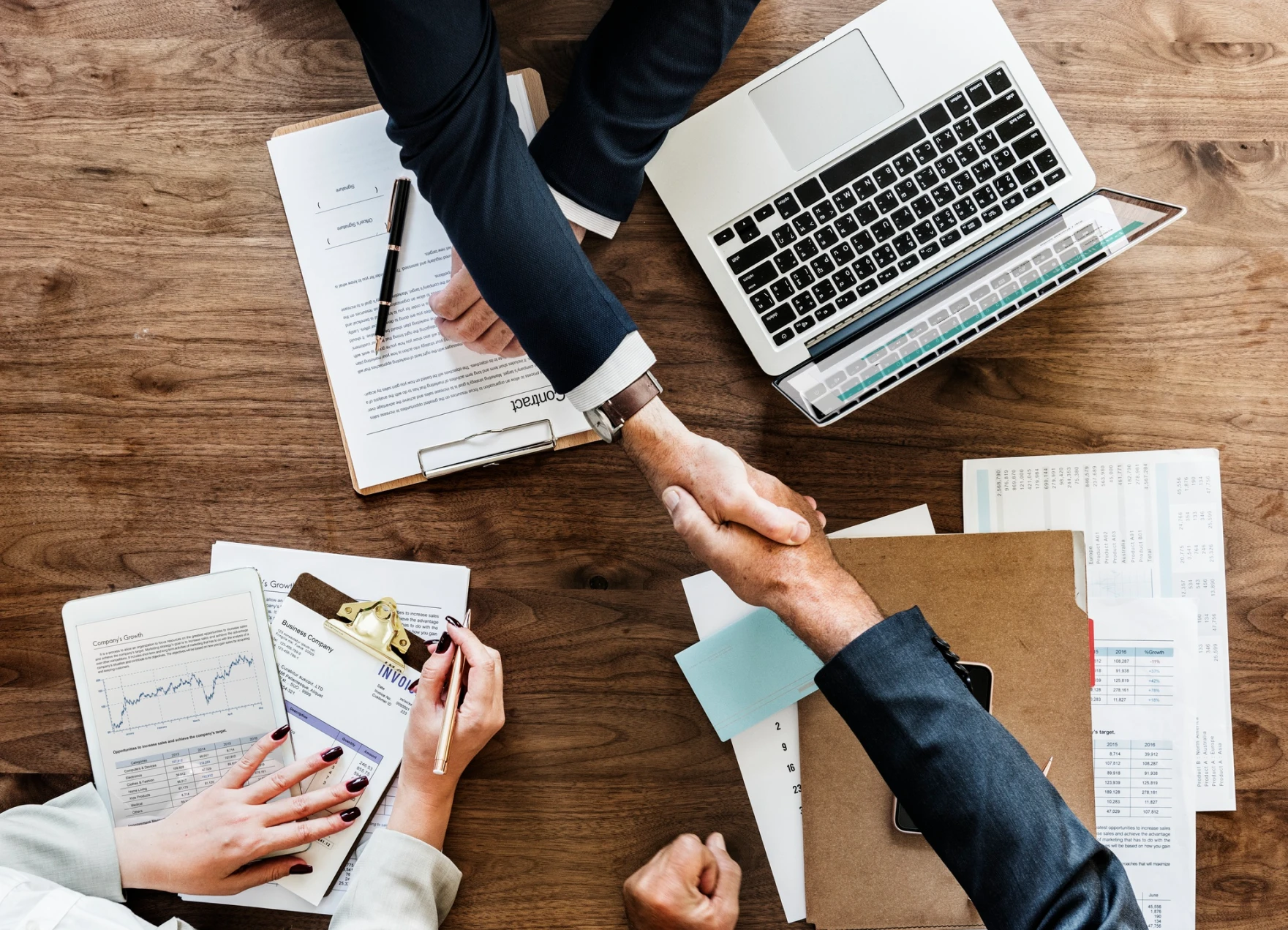 aerial shot of business people shaking hands over a desk